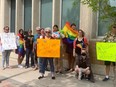 Fran Forsberg (with orange sign) organized a rally outside the Greater Saskatoon Catholic School division office in downtown Saskatoon on May 27, 2023 with her daughter Skylar Forsberg (holding Pride flag), who is one of the performers in the Rainbow Tent at Nutrien Children's Festival children's festival.